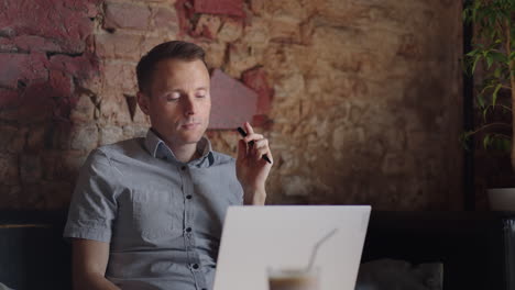 thoughtful serious young man student writer sit at home office desk with laptop thinking of inspiration search problem solution ideas lost in thoughts concept dreaming looking away