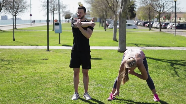 Jovens esportistas aquecendo antes do treino no parque.