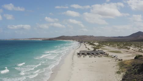 Drone-Se-Eleva-Sobre-Una-Pareja-Caminando-Por-La-Playa-De-Tecolote-En-Baja