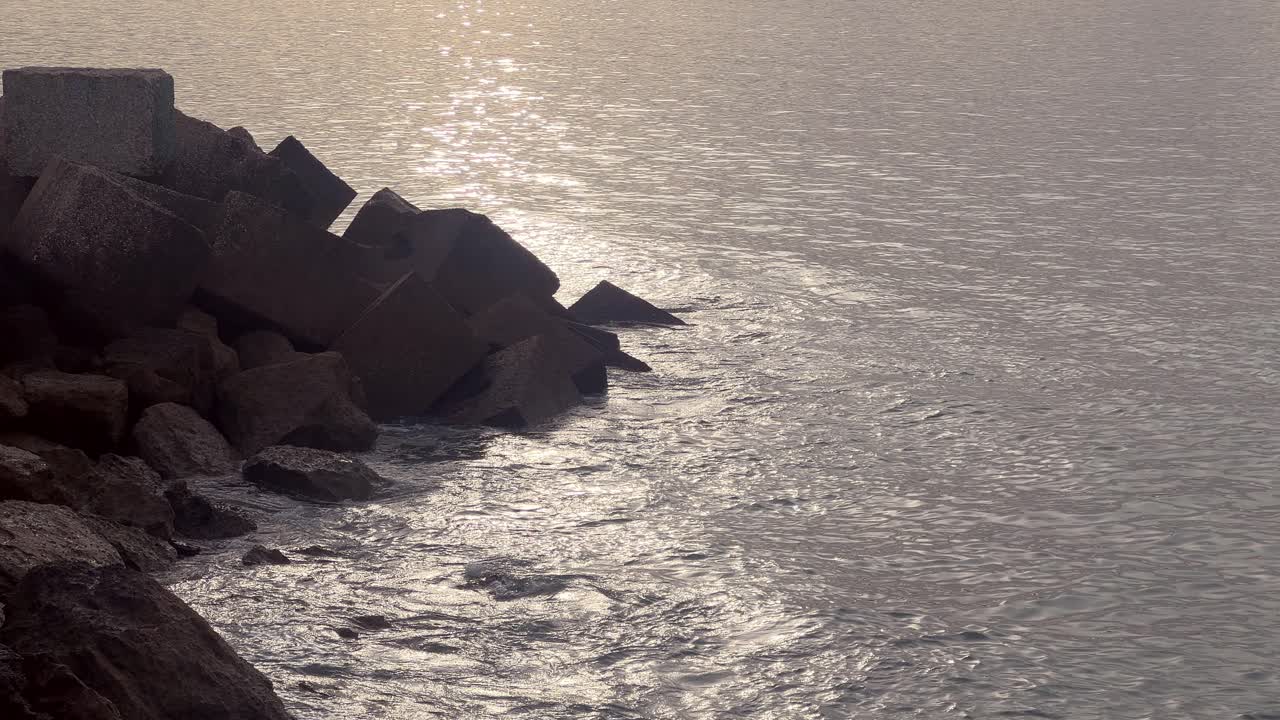 Static view of the sea breaking on the jagged coastline. Low angle