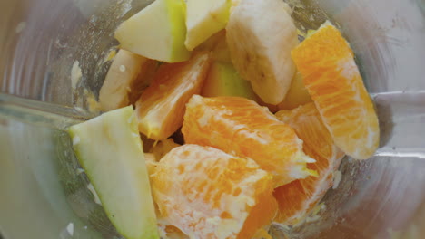 top view chopping blender full juicy fruits close up. vegetarian smoothie.