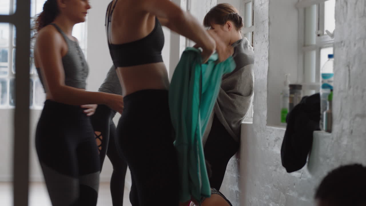 clase de yoga de mujeres hermosas y sanas preparándose para salir del estudio de fitness después de la práctica de entrenamiento