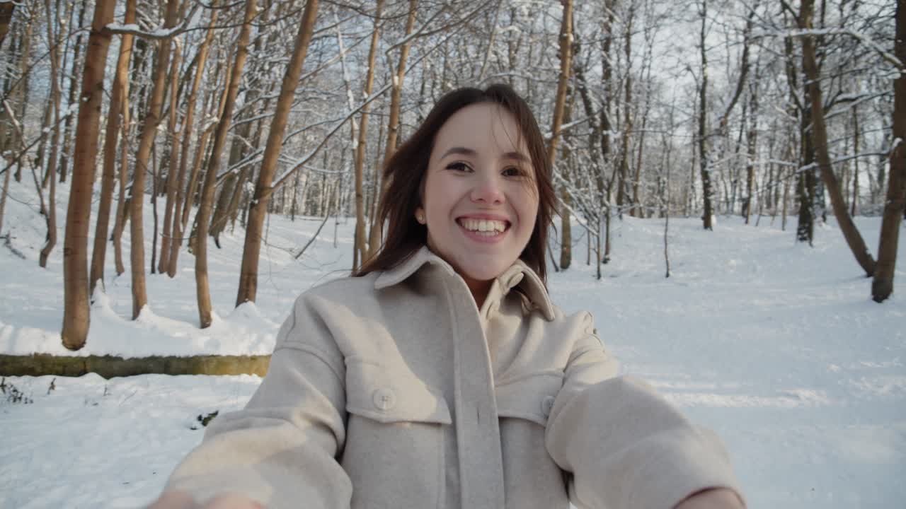feliz joven y hermosa pareja se divierten juntos en el soleado bosque de invierno