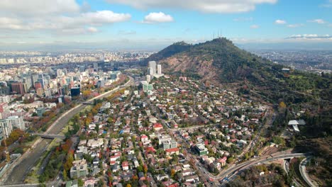 Aerial-drone-fly-San-Cristobal-hill,-Santiago-de-Chile-autumnal-andean-landscape-at-Pedro-de-Valdivia-neighborhood