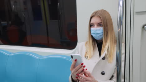 woman using phone in subway wearing mask