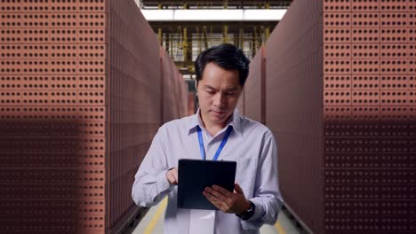 worker inspecting inventory in a brick warehouse
