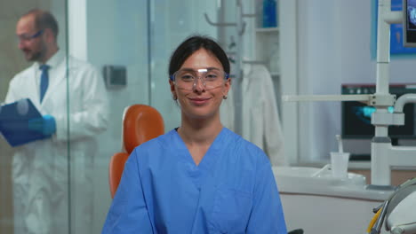 Nurse-smiling-at-camera-sitting-in-dental-office