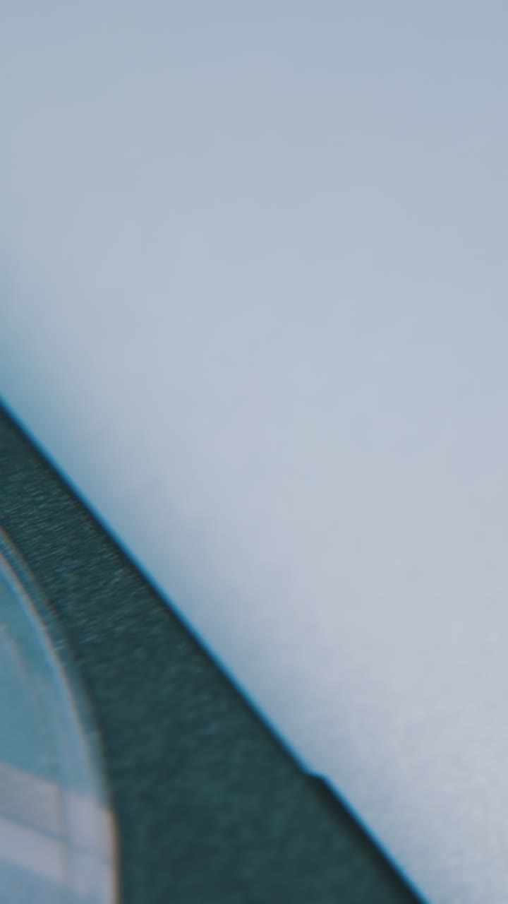 motion over black and blue plastic compact cassette with magnetic tape lying on white background extreme close view