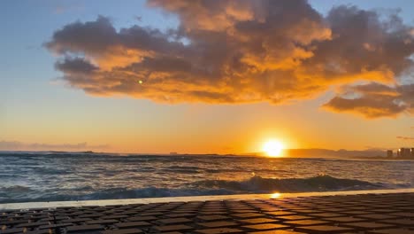 timelapse de la puesta de sol con olas salpicadas durante la hora dorada en waikiki