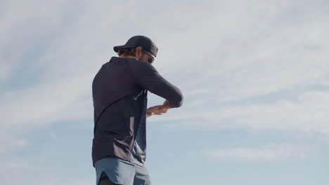 medium shot of a focused sportsman warming up and doing curls before outdoor workout