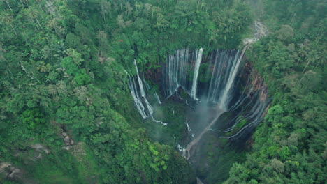 wide view of tumpak sewu waterfall and dense forest, east java