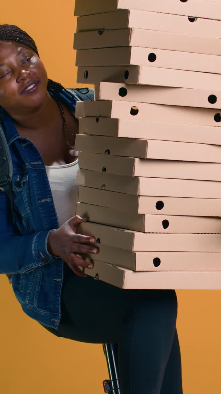 Wanita mengantarkan setumpuk kotak pizza
