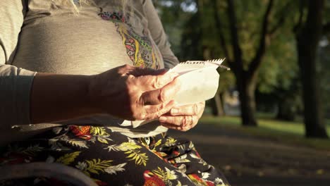 mujer madura leyendo carta en el parque plano medio