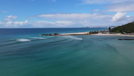 surfers floating on blue ocean surface near currumbin beach in gold coast, qld, australia