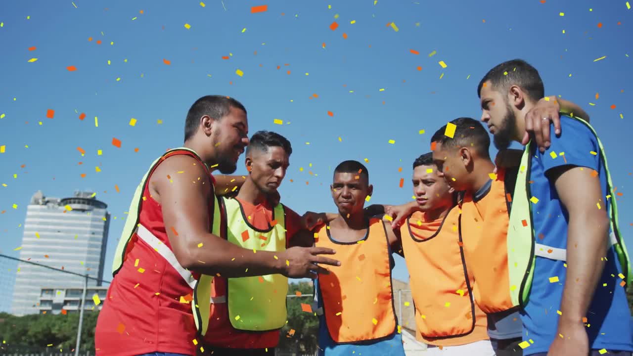 confeti colorido cayendo contra un equipo de jugadores de fútbol masculino discutiendo la estrategia del equipo