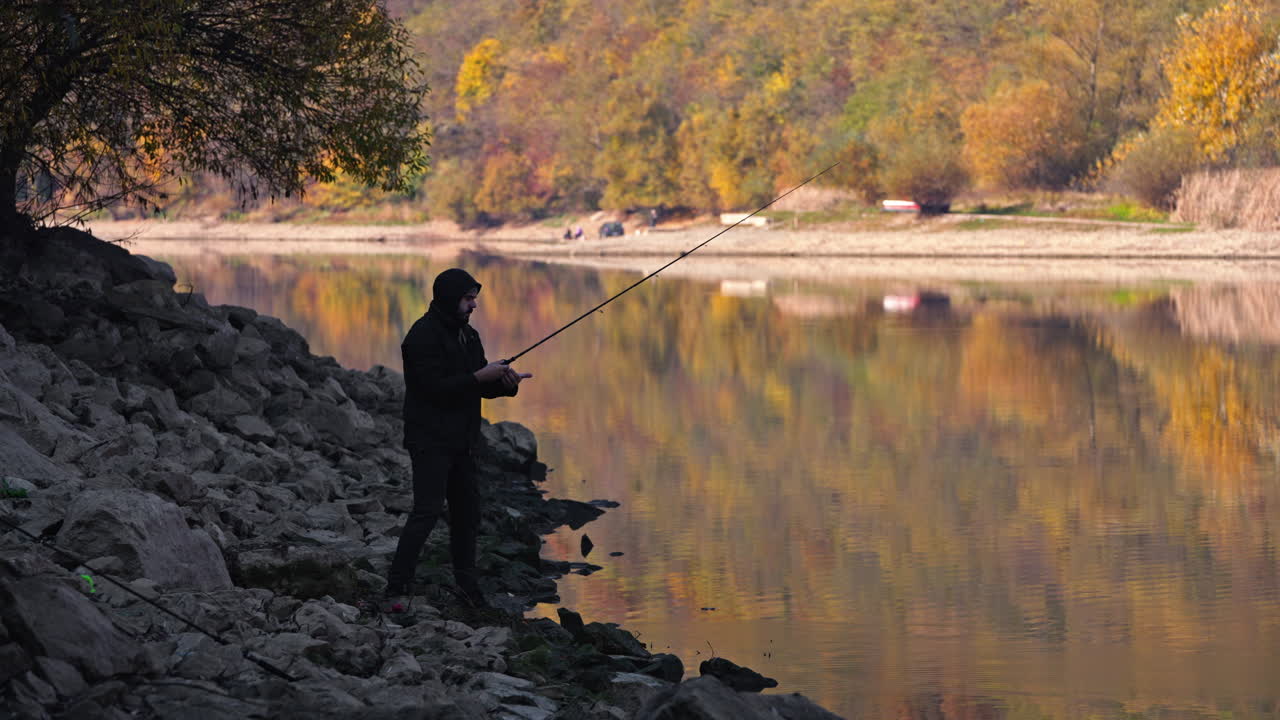 A fisherman enjoying an autumn day by the lake