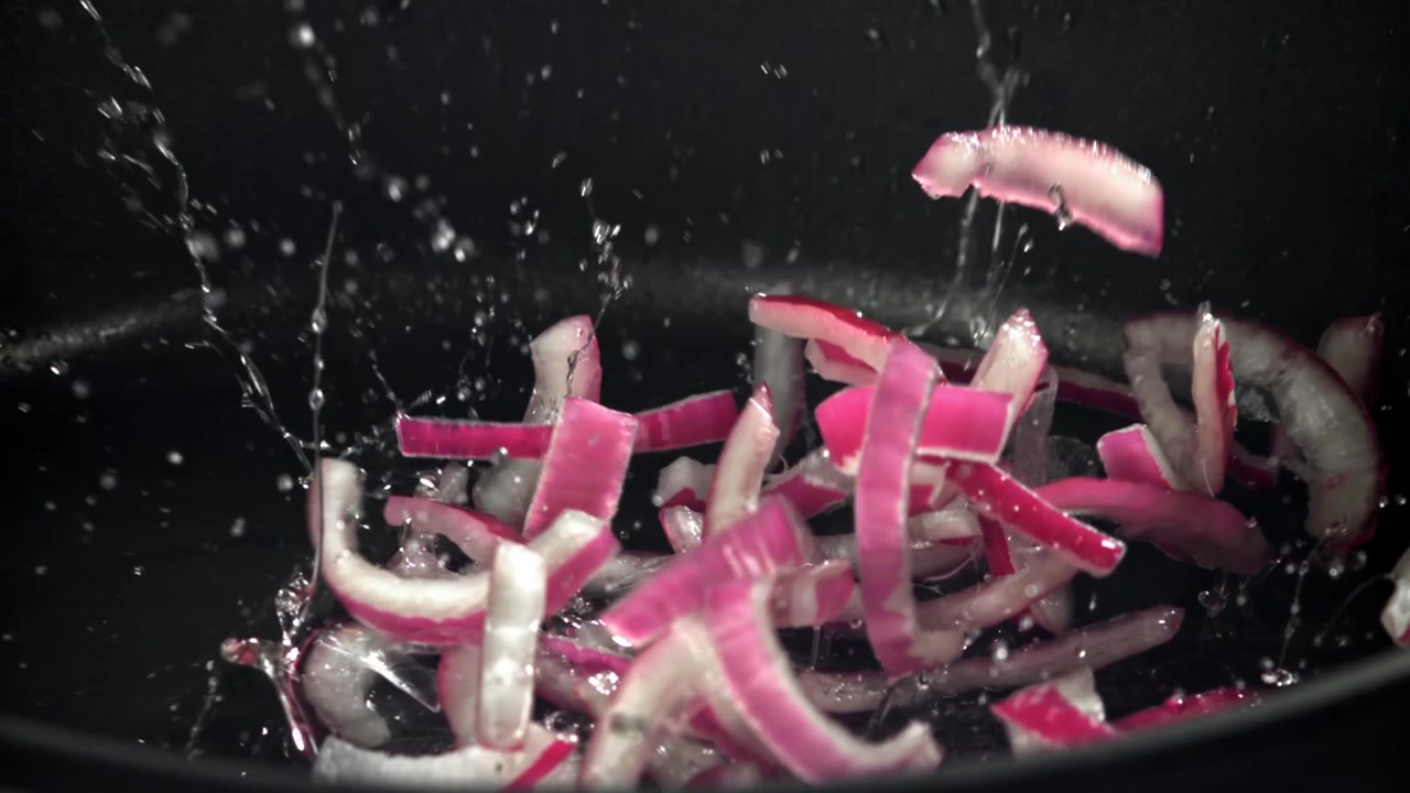 Fresh Red Onion Slices Falling into a Hot Pan