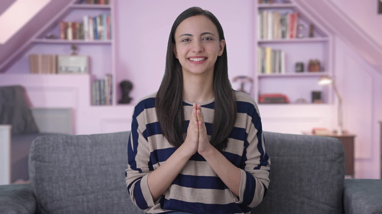 chica india feliz haciendo namaste