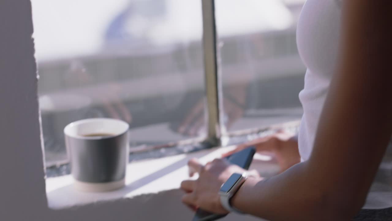 young woman hands using smartphone browsing messages enjoying texting on mobile phone at home wearing smartwatch close up