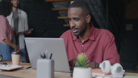 man working on a laptop in a modern office setting