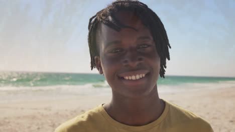 animation of happy african american man over seascape and grass