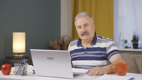 home office worker old man looking annoyed at camera.