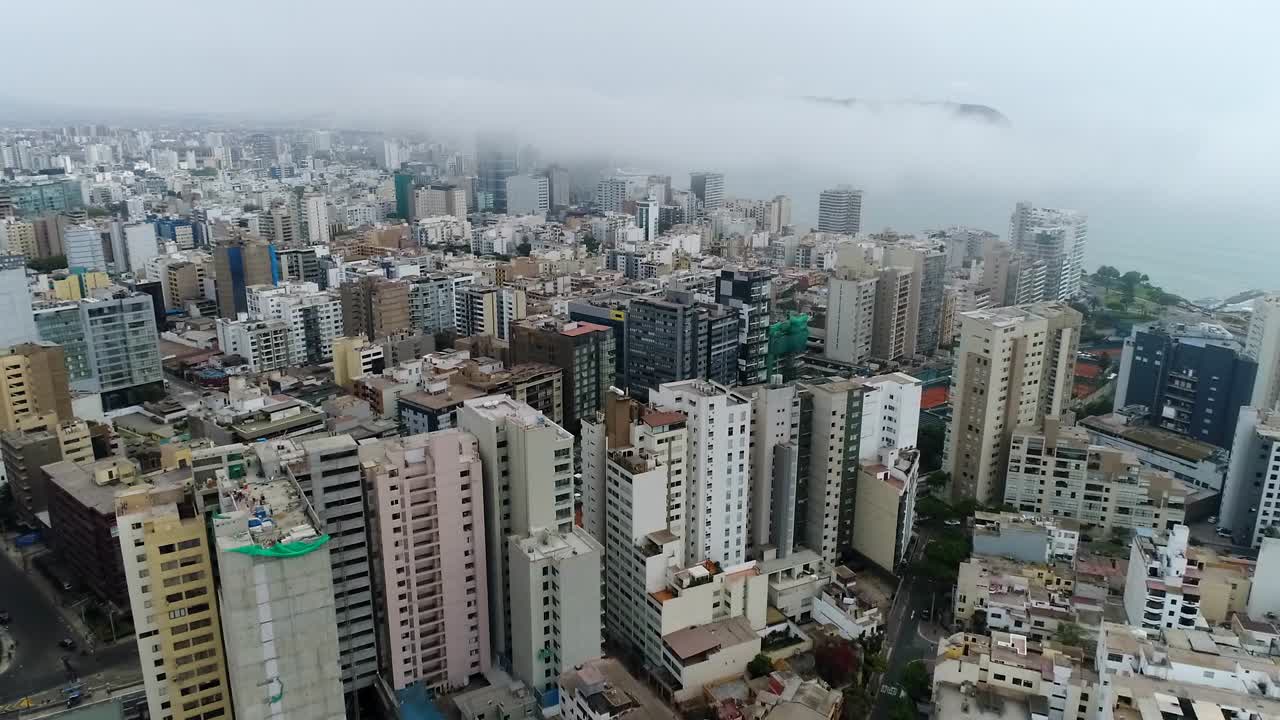 vista de drones sobre lima perú, edificios altos y el océano al fondo