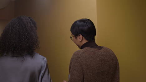 two people walking down a hallway