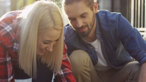 close up view of the young couple playing and petting corgi dog while they walking it on the street