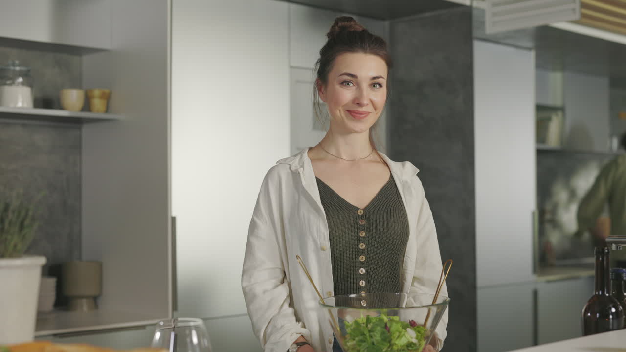 Mujer prepara ensalada fresca en cocina moderna