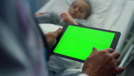 Arzt-Berührt-Tablette-Mit-Grünem-Bildschirm,-Nahaufnahme.-Krankes-Mädchen,-Das-Im-Krankenhausbett-Liegt.