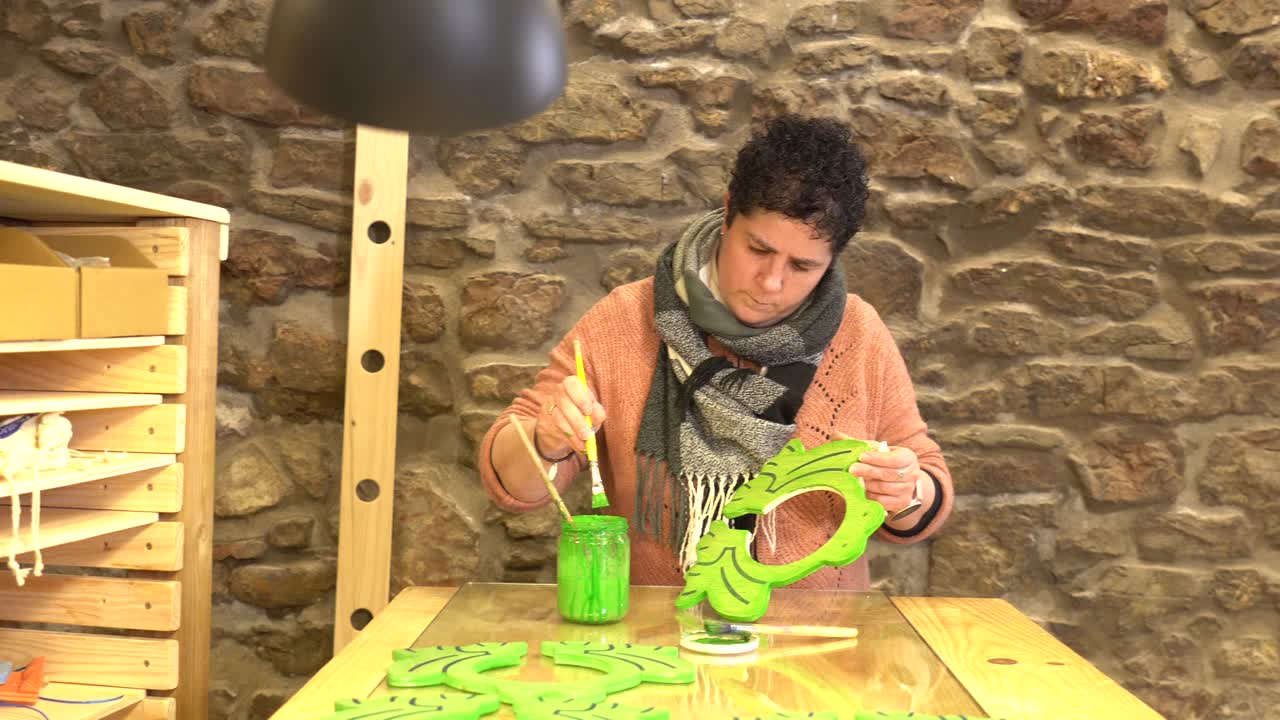 Person painting craft project at table