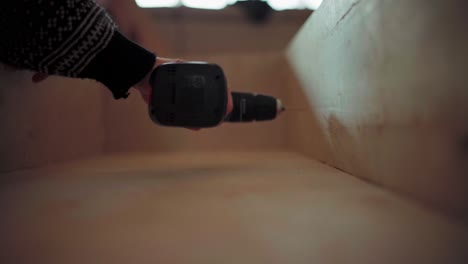 persona perforando agujeros en la madera usando un taladro inalámbrico
