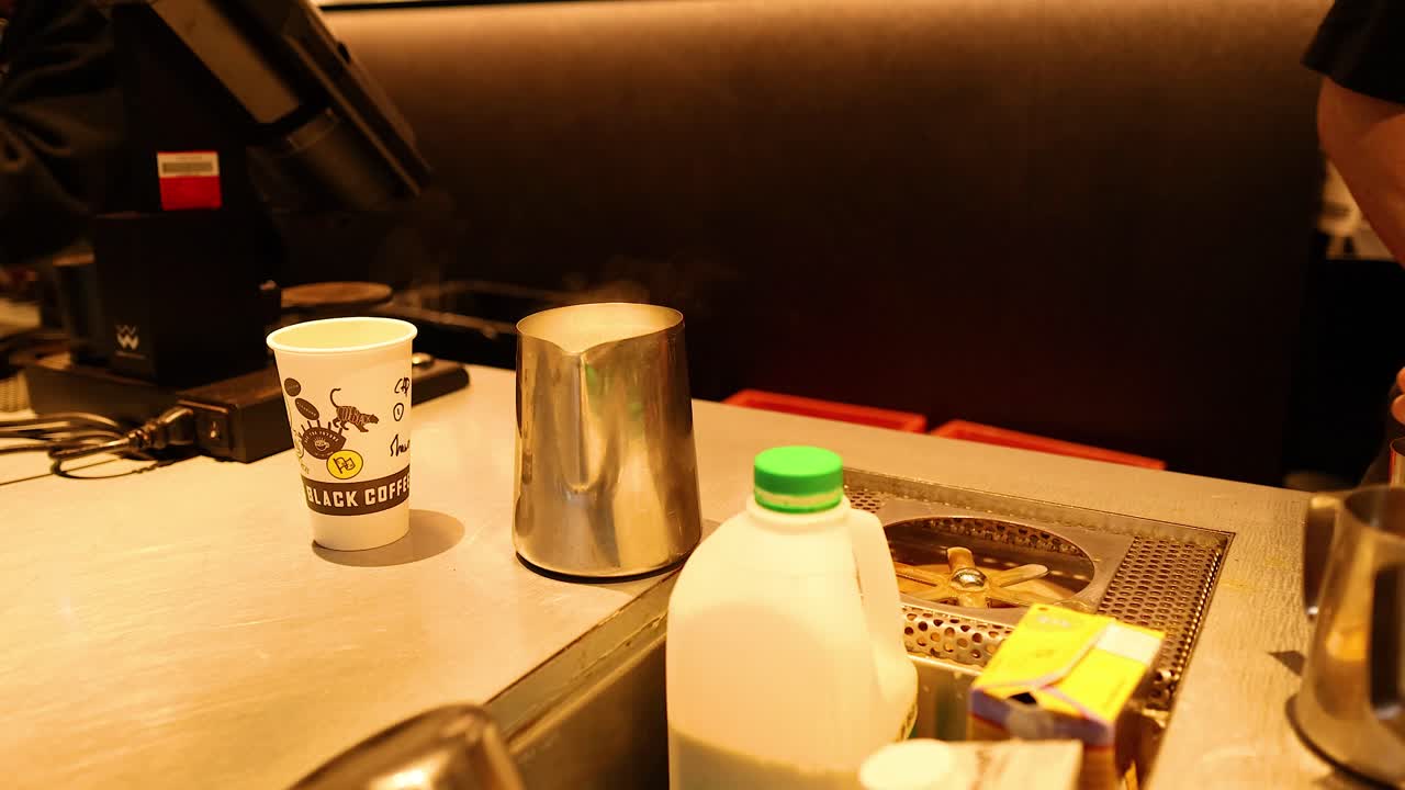 바리스타 가 유리잔 을 고 커피 를 준비 하고 있다