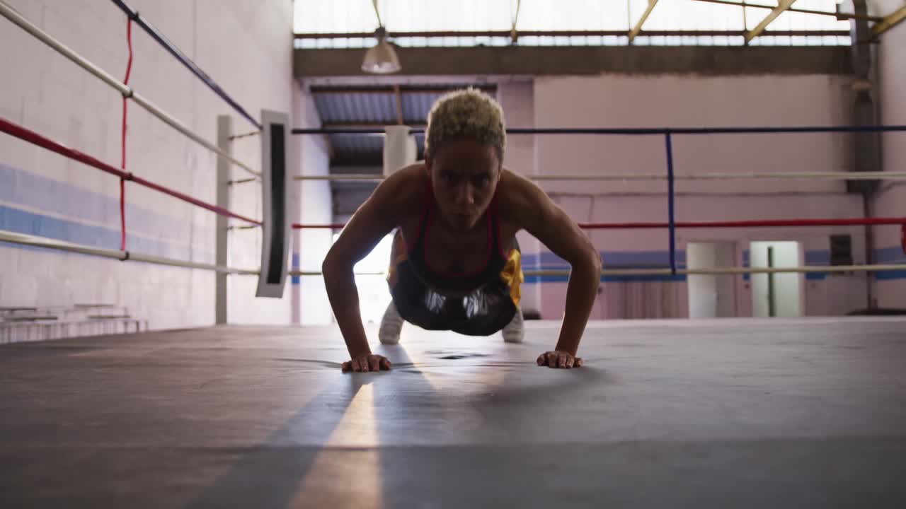 mujer de raza mixta trabajando en el gimnasio de boxeo