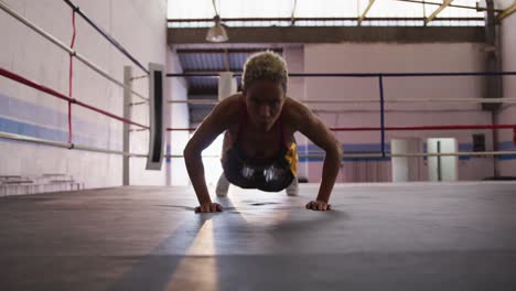 mixed race woman working out in boxing gym