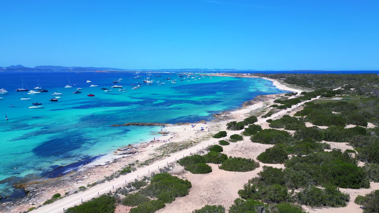 Barche ancorate nelle splendide acque turchesi e cristalline di Formentera, una spiaggia di sabbia bianca con Posidonia oceanica. Perfetta ripresa aerea panoramica a sinistra con drone