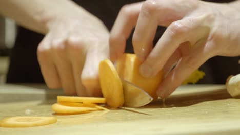 cutting carrot with knife on round pieces