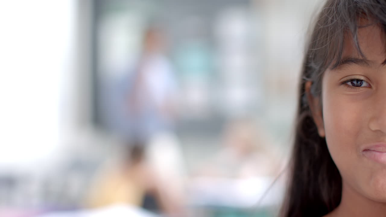 Biracial girl in focus at school, with copy space
