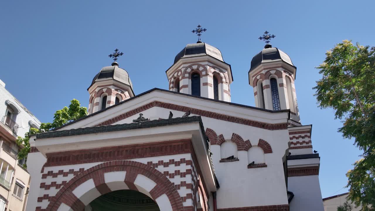 Vista esterna dal basso verso l'alto delle cupole della chiesa di Zlatari a Bucarest, che mette in risalto l'architettura religiosa tradizionale rumena e i dettagli decorati