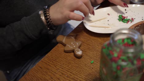 close-up shot of a lady putting icing on a gingerbread man
