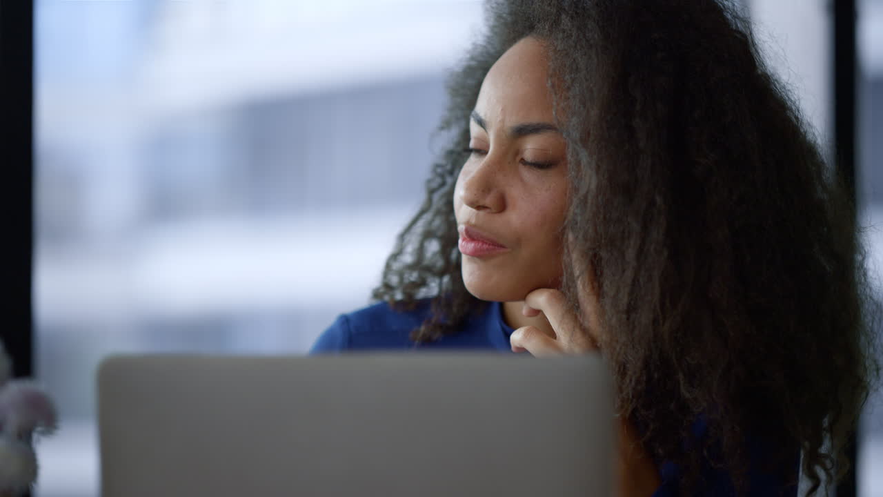 Focused african american businesswoman searching laptop internet in home office.