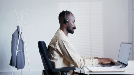 businessperson working on laptop with headset