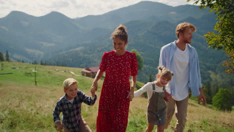 Happy-walking-family-enjoying-summer-vacation-on-hill.-Holiday-with-children.