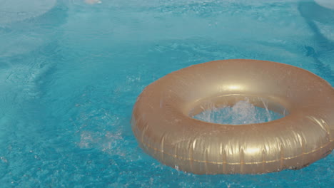 the child dives into the pool, jumps into the waters and into the center of the inflatable circle. summer fun in hot weather