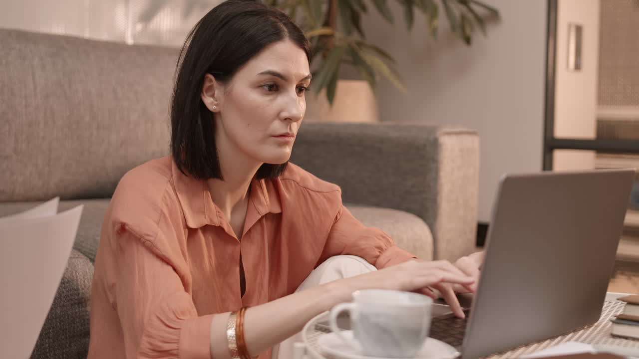 Woman Using Laptop on Coffee Table