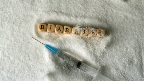 syringe falling into pile of sugar beside dice spelling diabetes