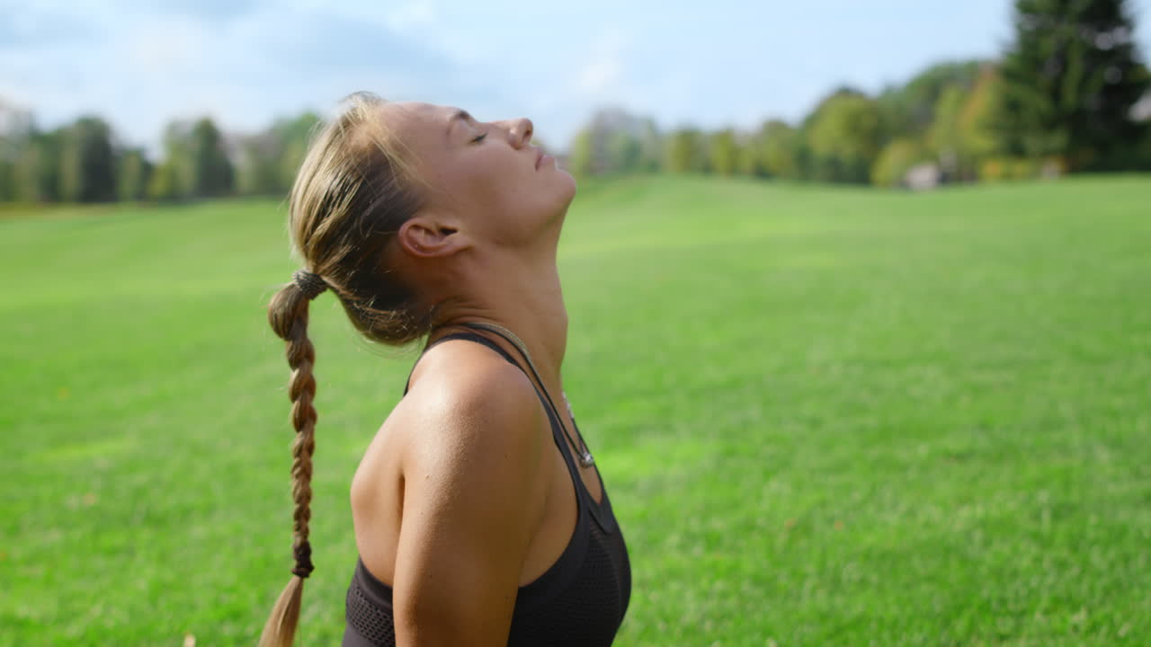 Atleta con arto artificiale che fa yoga al parco. Donna che si allunga in un campo.