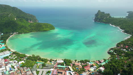 Vibrant-green-protected-bay-of-koh-phi-phi,-cloud-shadows-dance-on-ocean-surface