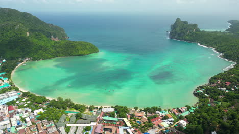 vibrant green protected bay of koh phi phi, cloud shadows dance on ocean surface